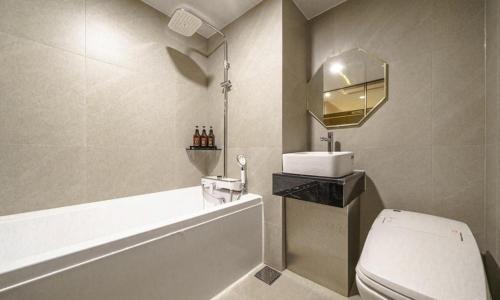 a bathroom with a toilet and a sink and a tub at Paju Geumchon Grache in Paju