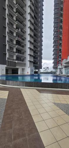 a swimming pool in the middle of two tall buildings at KP1011 Guest House in Puchong