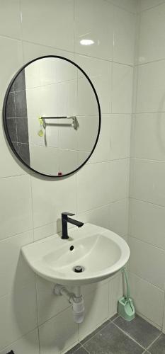 a bathroom with a white sink and a mirror at KP1011 Guest House in Puchong