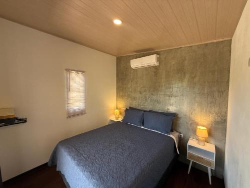 a bedroom with a bed with blue pillows at Avellanas Tiny Villa 1BR Private Self check in in Santa Cruz
