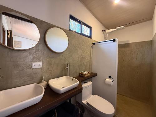 a bathroom with a sink and a toilet and a mirror at Avellanas Tiny Villa 1BR Private Self check in in Santa Cruz