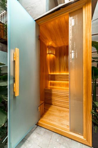 an indoor sauna with wooden walls and a glass door at My Khe Hotel in Danang