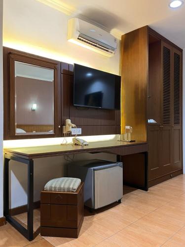 a room with a desk with a television on a wall at Citra Boutique Hotel Cikarang in Cikarang
