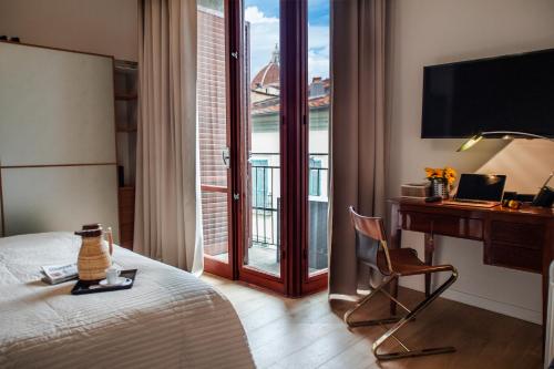 um quarto de hotel com uma cama e uma secretária com um computador em Opera Florence Apartments em Florença
