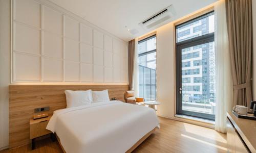 a bedroom with a white bed and a large window at The hound hotel bandalseom2 in Ansan