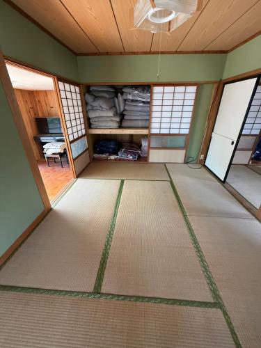 an empty room with green walls and a ceiling at ゲストハウスめぐみ in Iizuka