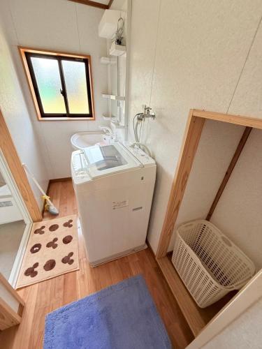 a small bathroom with a sink and a mirror at ゲストハウスめぐみ in Iizuka