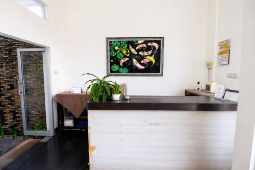 a kitchen with a counter with a painting on the wall at Nest Hotel Jogja in Seturan