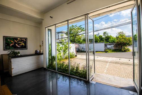 an empty room with a large glass door to a garden at Nest Hotel Jogja in Seturan
