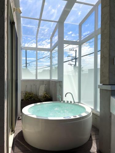 a bath tub in a room with a large window at Kamakura Private Pool & Sauna Villa - Casablanca Pool House in Kamakura