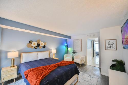 a bedroom with a bed with a blue wall at Spacious Beach Condo Double Suite for Couples Getaway in Myrtle Beach