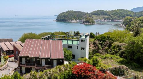 an aerial view of a house on a hill next to the water at Geoje Erion Pet-Friendly Pension in Geoje