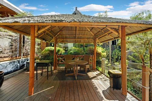 eine hölzerne Pergola mit Tisch und Stühlen auf einer Terrasse in der Unterkunft The Executive Suite in Pemberton