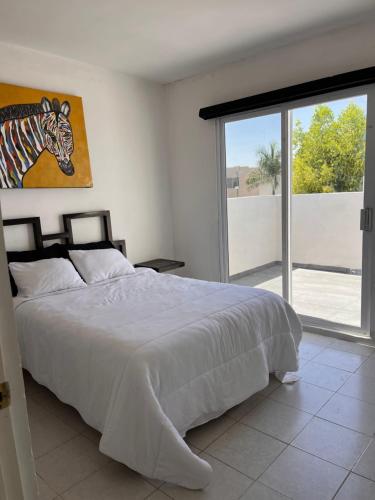 a bedroom with a bed with a painting of a zebra at Casa completa, 4 dormitorios, 7 camas dobles, 4 sofá cama, 3 baños 1 en planta baja, cocina equipada, consola Arcade, asador, juguetes para niños, plancha, secadora, cafetera, etc, fraccionamiento privado, zona de vías rápidas y toallas in Torreón