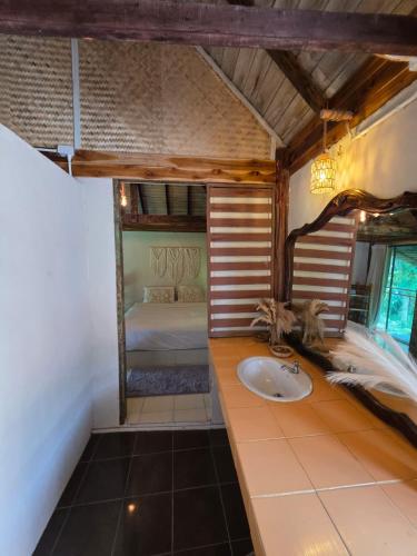 a bathroom with a sink and a bed in a room at nam jai pai in Ban Wiang Nua