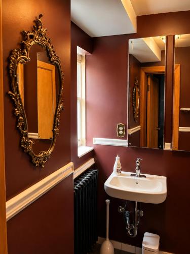 a bathroom with a sink and a mirror at Winston Churchill - le charme Tudor au cœur de Sherbrooke in Sherbrooke