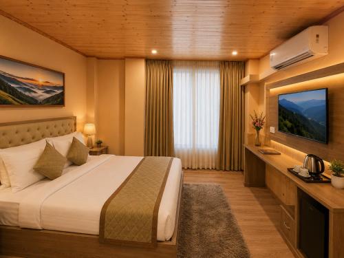 a hotel room with a bed and a television at Mist Valley By Zenia in Fagu