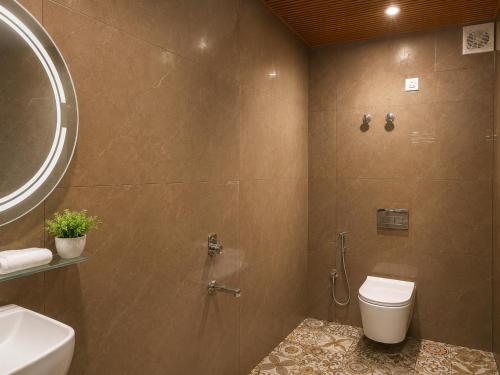 a bathroom with a shower with a toilet and a sink at Mist Valley By Zenia in Fagu