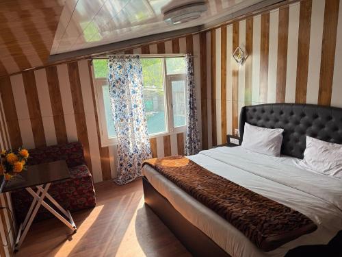 a bedroom with a large bed and a window at Zabaish Riverside Cottage in Pahalgām