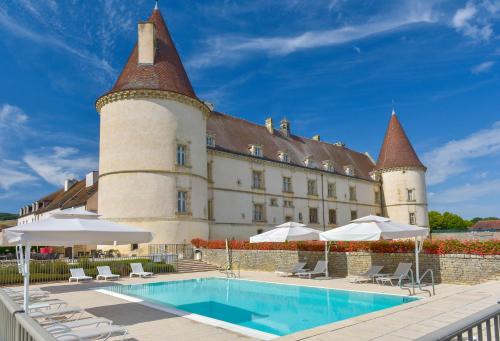 un edificio con piscina di fronte ad esso di Hôtel Golf Château de Chailly a Chailly-sur-Armançon
