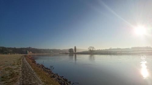 a view of a river with the sun in the background at Wohnung mit Weitblick in Dresden