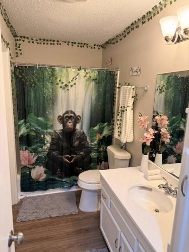 a bathroom with a monkey shower curtain with a toilet at 2 King Suites w/ Private Baths + Workspaces | LSU in Baton Rouge