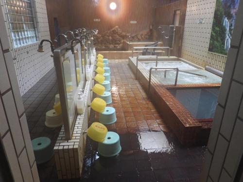 a group of toilets in a bathroom with a tub at Ebeotsu Onsen in Takikawa