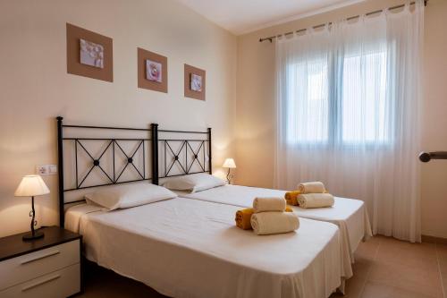 Un dormitorio con dos camas con toallas encima. en Residence Club Deluxe, en Sa Ràpita