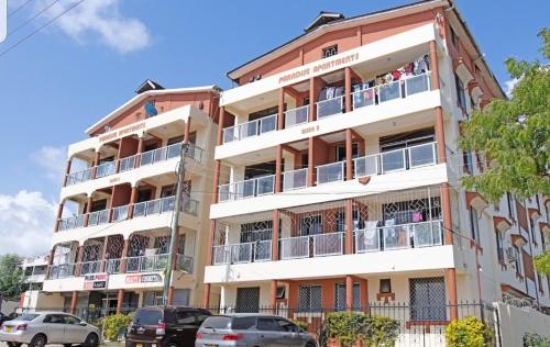 a tall building with cars parked in front of it at House Stark in Kilifi