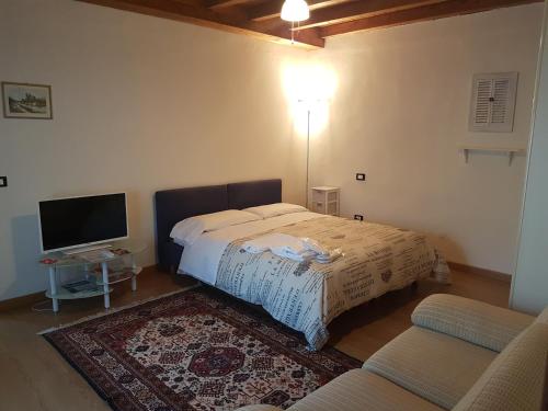 a bedroom with a bed and a flat screen tv at Corte Pomponazza in Mantova