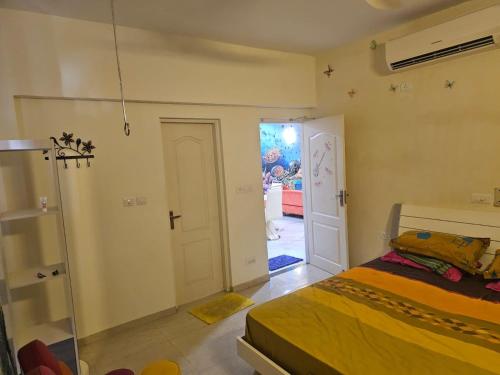 a bedroom with a bed and a door to a room at Sunstar in Coimbatore