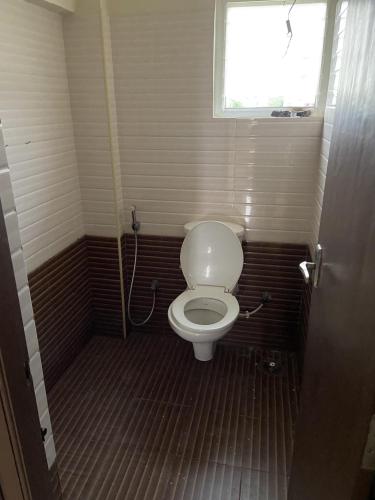 a small bathroom with a toilet and a window at Sunstar in Coimbatore