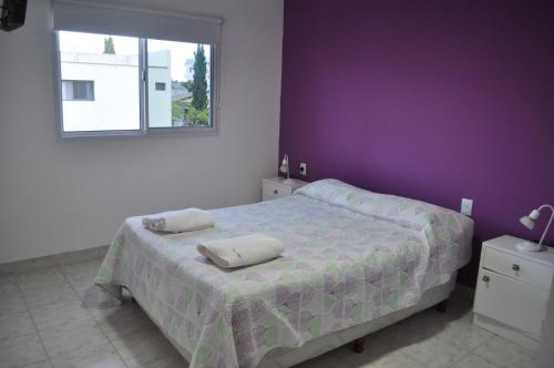 a bedroom with a bed and a purple wall at Los Abus in Colón