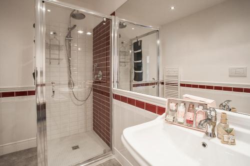 uma casa de banho com um chuveiro, um lavatório e um chuveiro em Opera Florence Apartments em Florença