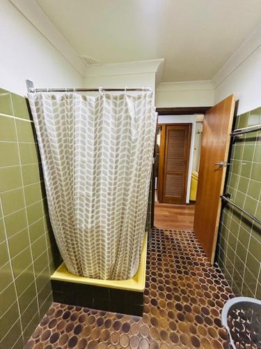 a bathroom with a shower with a tiled floor at Stouty's at Hat Head - No Sheets or Towels Provided in Hat Head