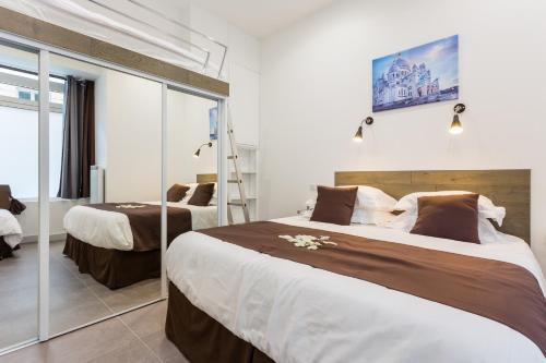 une chambre d'hôtel avec deux lits et une échelle dans l'établissement Le Logis de Montmartre, à Paris