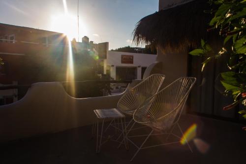 two chairs and a table on a balcony at Kinbe Hotel Boutique in Playa del Carmen