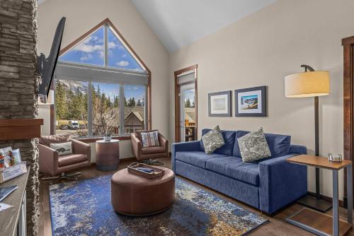 a living room with a blue couch and chairs at The Eagle Suite at Stoneridge Mountain Resort in Canmore
