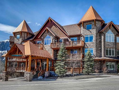 a large log home with a deck on the front at The Eagle Suite at Stoneridge Mountain Resort in Canmore
