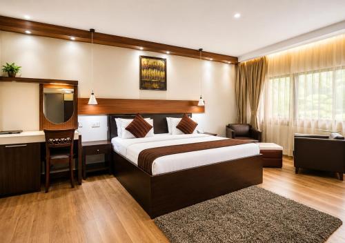 a hotel room with a bed and a desk and a television at Chelsea Hotel Abuja in Abuja