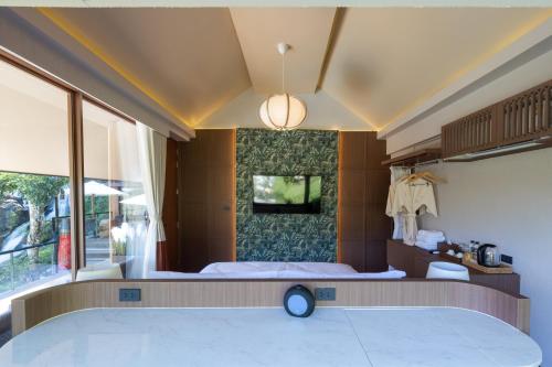 a bedroom with a large bed and a large window at J Valley Resort in Pong Yaeng