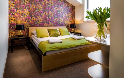 1 dormitorio con 1 cama con pared de flores en Rezydencja na Wzgórzu en Lodz