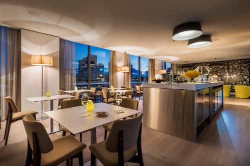 a restaurant with tables and chairs and a bar at PARKROYAL Parramatta in Sydney