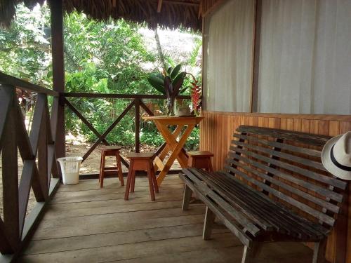 a wooden porch with a bench and a table at Tambopata River in Puerto Maldonado