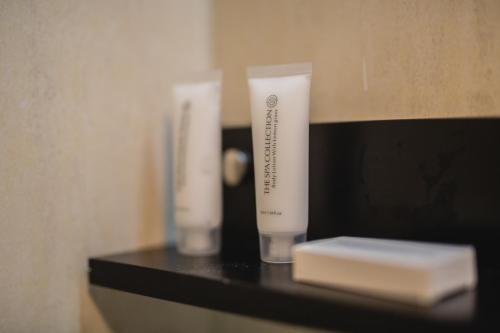 a black shelf with two tubes of soap on it at The Pier Beach Inn & Suites in Willemstad