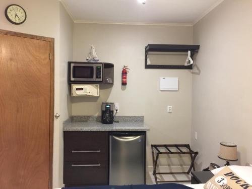 a small kitchen with a microwave and a counter at The Pier Beach Inn & Suites in Willemstad