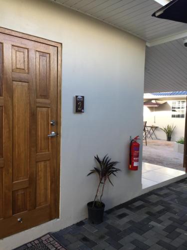 a fire extinguisher next to a wooden door at The Pier Beach Inn & Suites in Willemstad