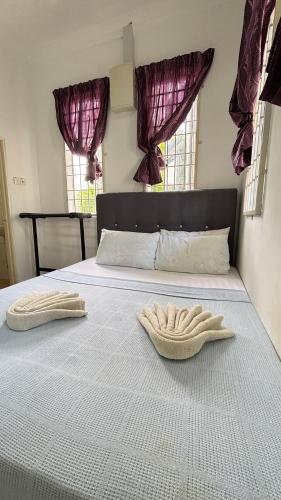 two towels are sitting on a bed in a bedroom at Ayem Resort Langkawi in Air Hangat