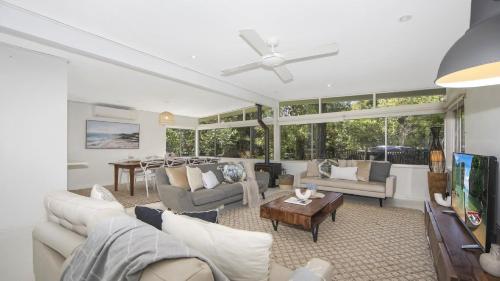 a living room with white furniture and windows at Pool, Pet - Friendly, Fireplace, Walk To Beach in Pearl Beach