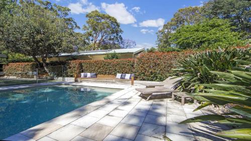 a swimming pool with a bench and a house at Pool, Pet - Friendly, Fireplace, Walk To Beach in Pearl Beach